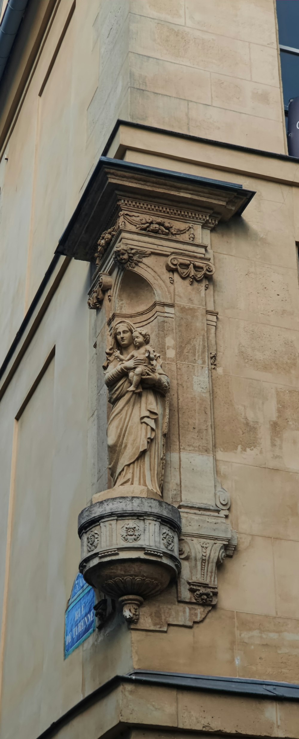 a stone building with a statue on the side