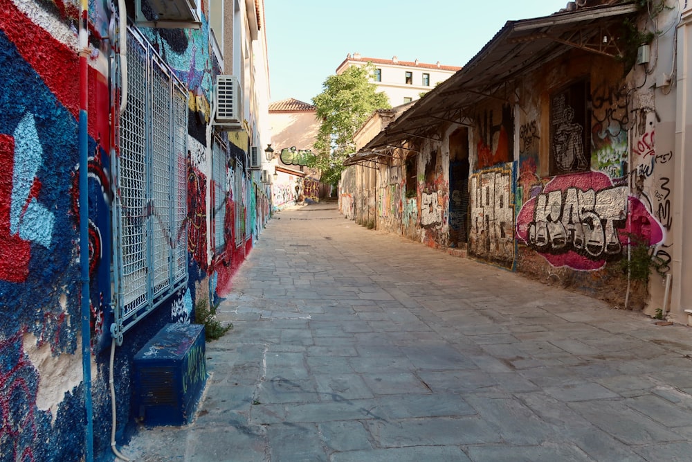 a cobblestone street with graffiti on the walls