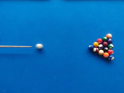 a pool table with balls and a cue
