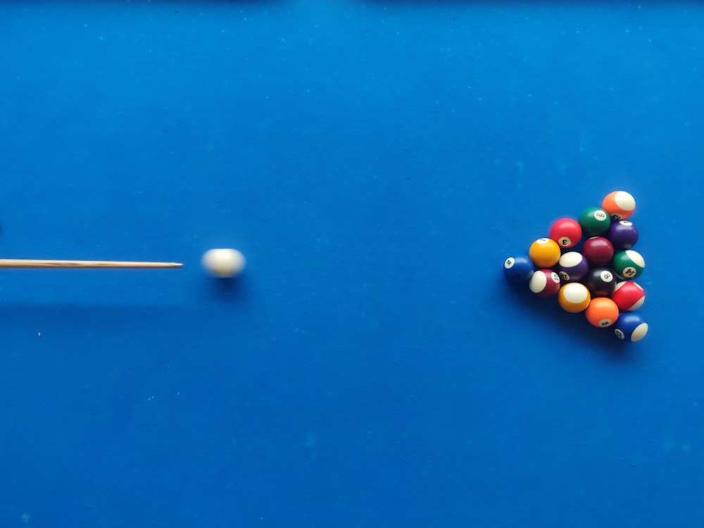 a pool table with balls and a cue