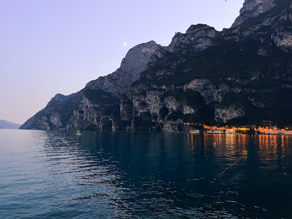 a body of water with a rocky mountain in the background