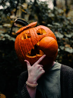 a person holding a carved pumpkin