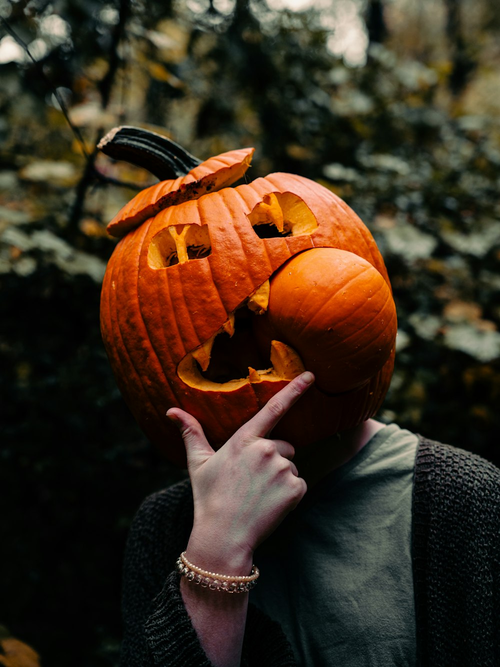 a person holding a carved pumpkin