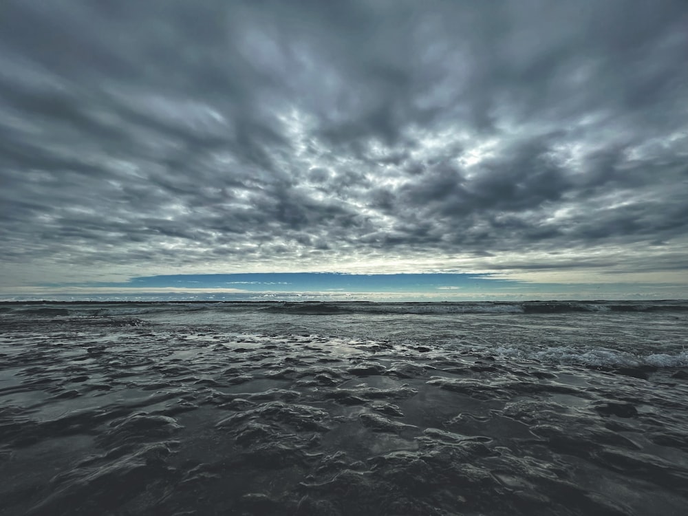 a body of water with clouds above