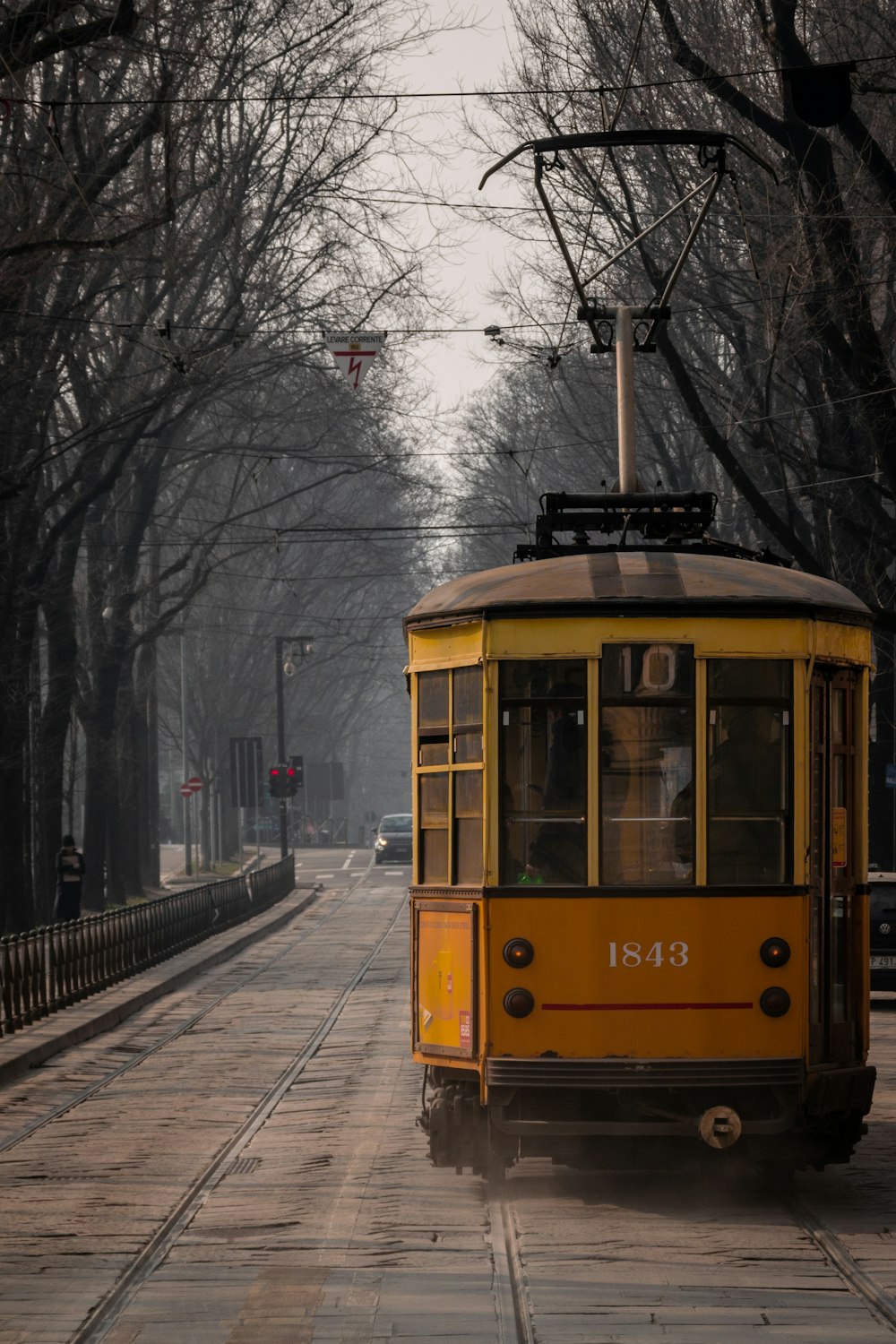 Ein gelber Straßenbahnwagen auf einer verschneiten Straße