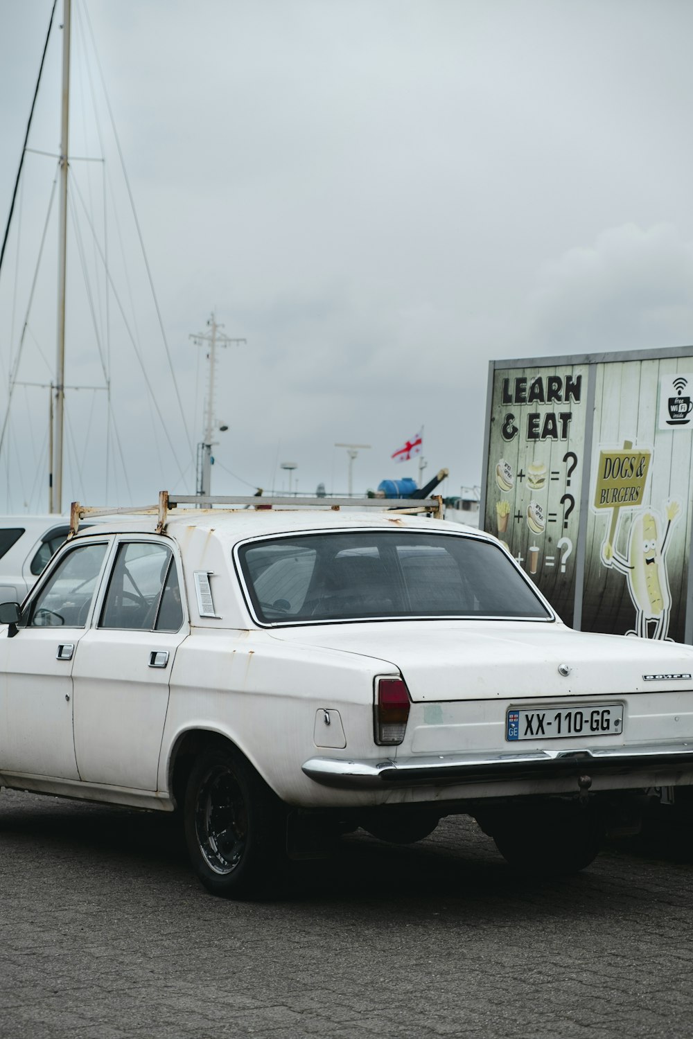 a white car parked next to a boat
