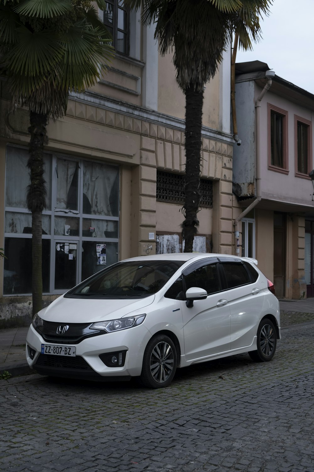 a white car parked in front of a building