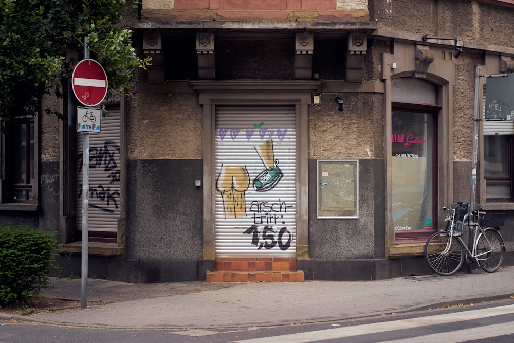 a bicycle parked in front of a building with graffiti on it