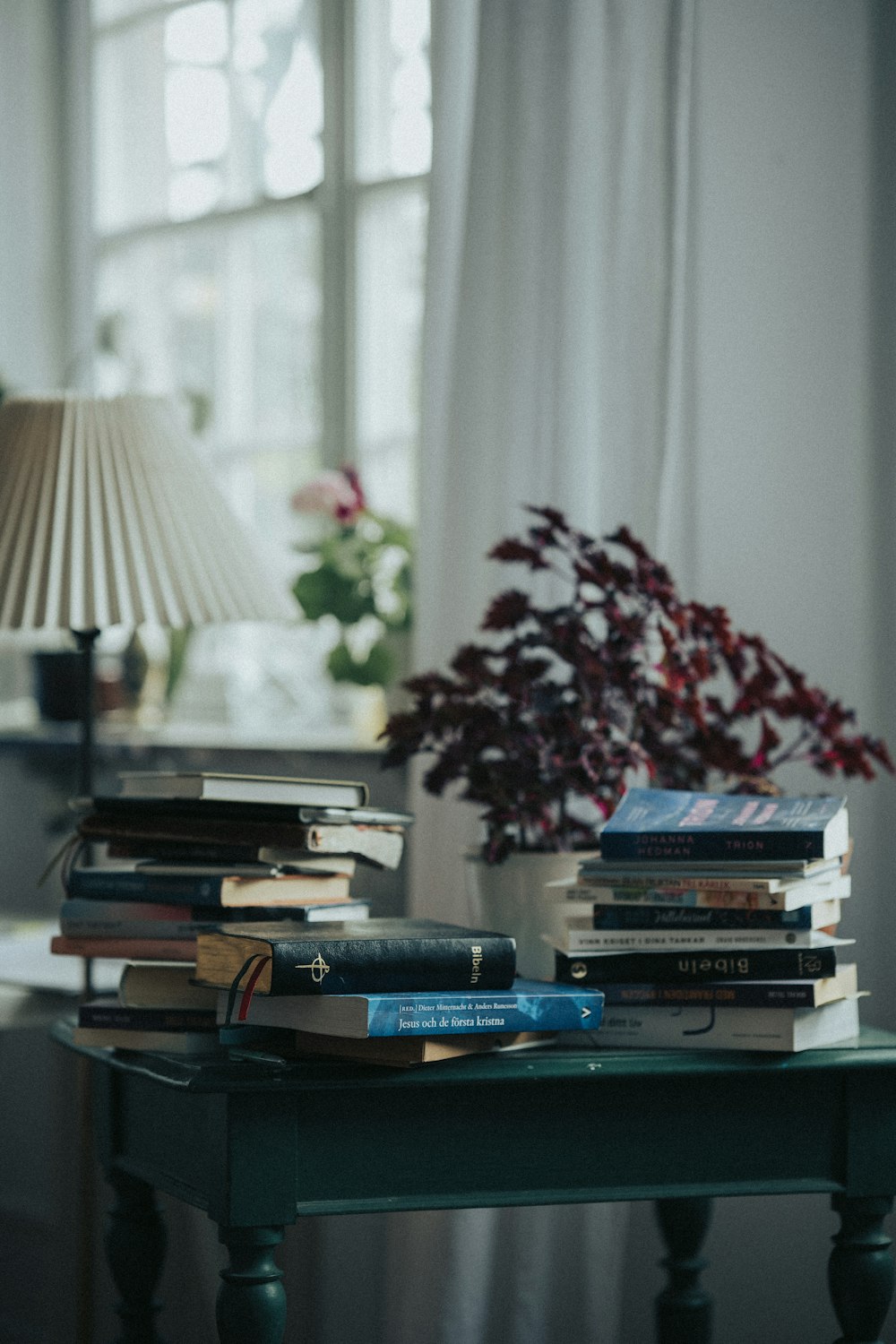 a table with a lamp and a stack of books on it