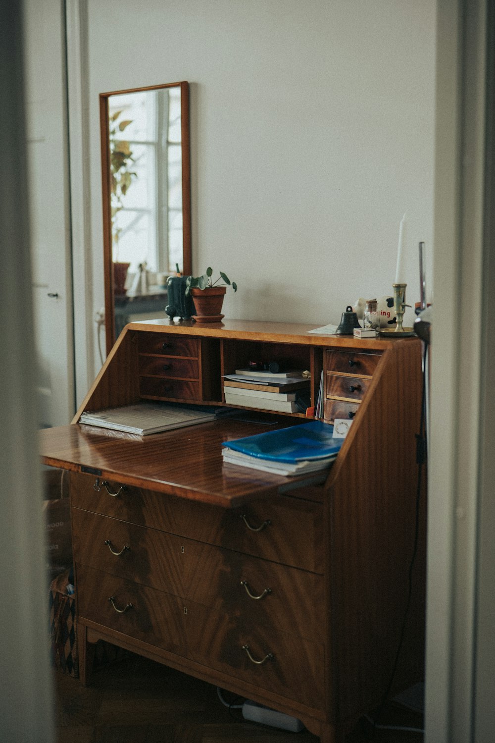 a desk with books and a mirror
