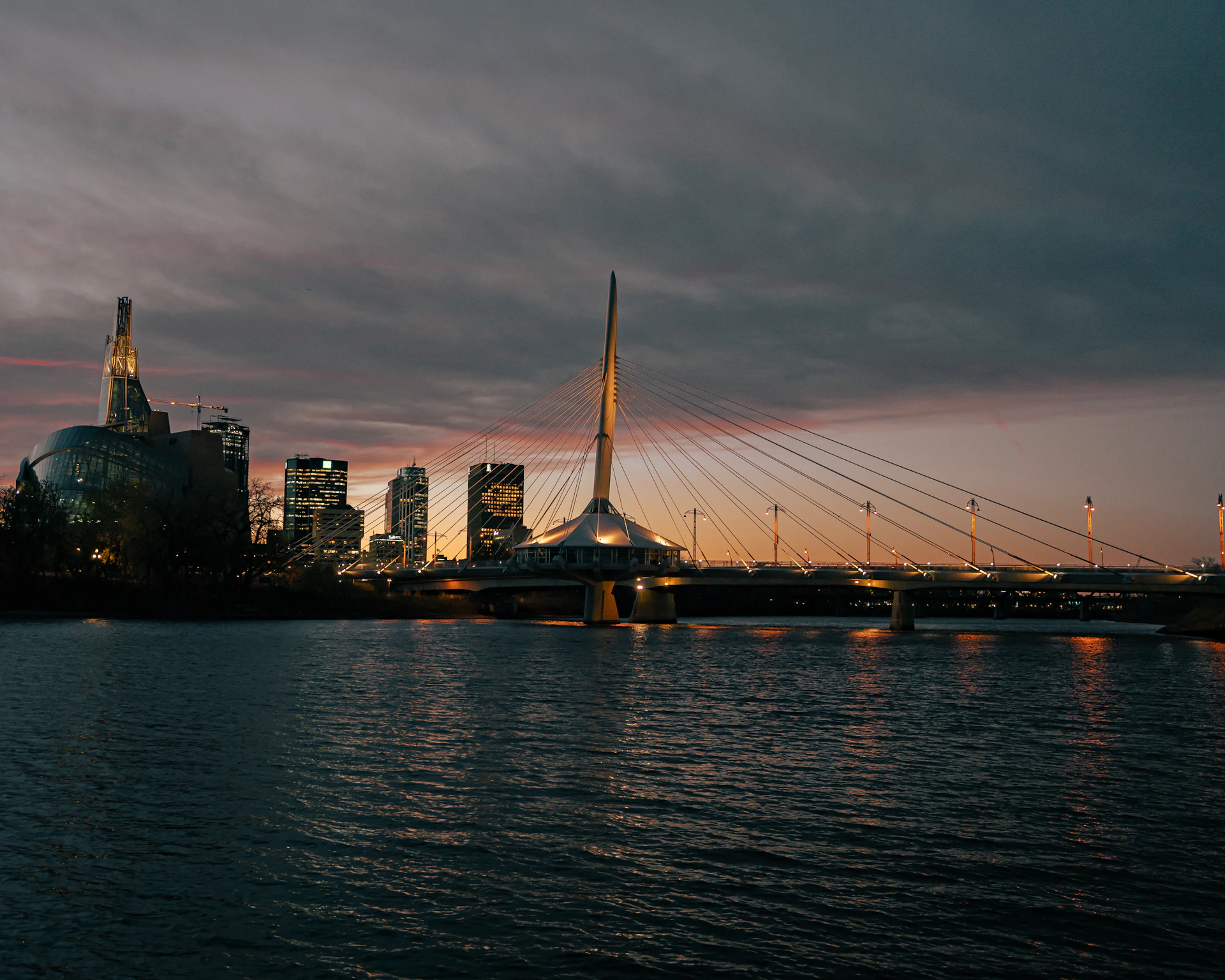 a bridge over water with a city in the background