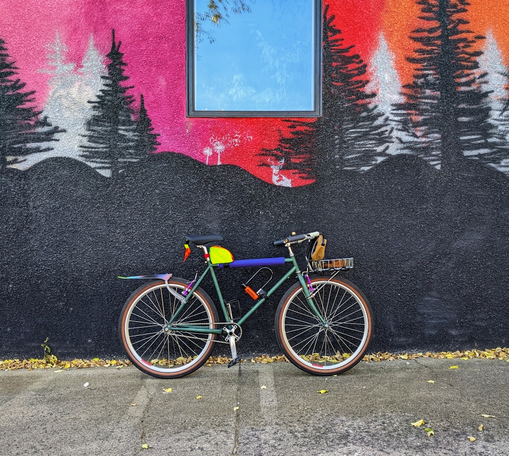 a bicycle parked in front of a wall with graffiti