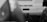 A black and white photograph of the rear of a vehicle with an out-of-focus foreground. The vehicle's prominent feature is the text 'I'm a servant' displayed on its back. The image includes visible vehicle accessories like a tow hitch and part of a tire.