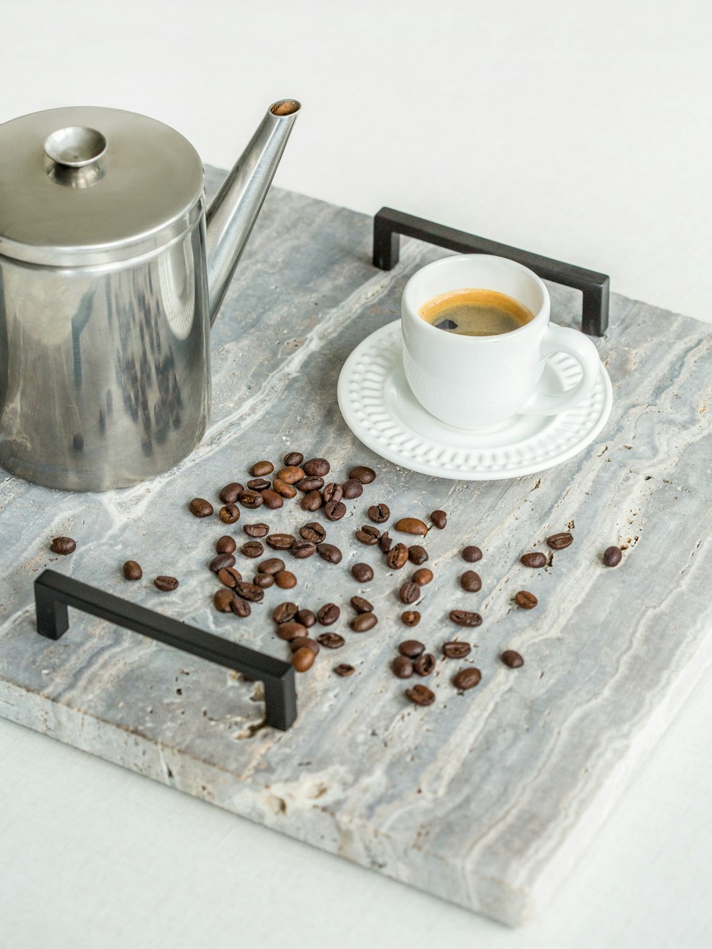 coffee cup and saucer on a table with coffee beans