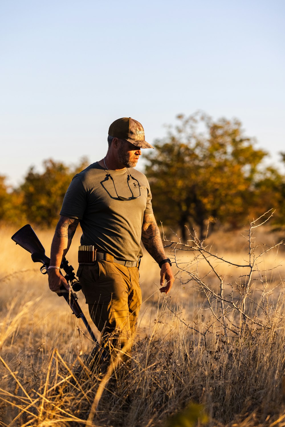 Un hombre sosteniendo un arma en un campo