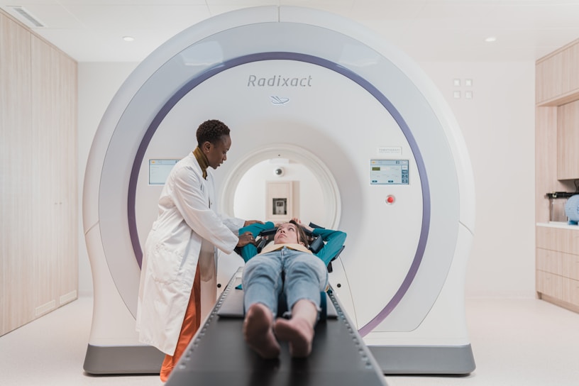 A technician repairing an X-ray machine in a clinical setting.
