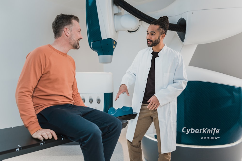 a person sitting on a chair next to a person in a suit