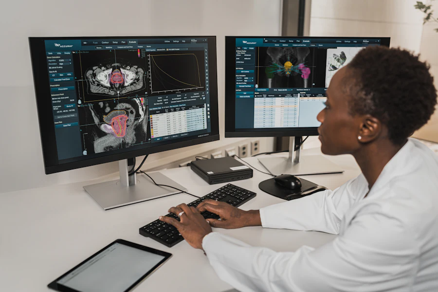 Healthcare professional reviewing clinical records on dual monitors