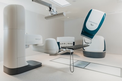 a room with a chair and a table with a computer on it