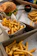 Close-up of a Swiss mushroom burger with crispy fries on a rustic wooden table.