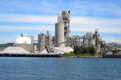 a large factory building next to a body of water