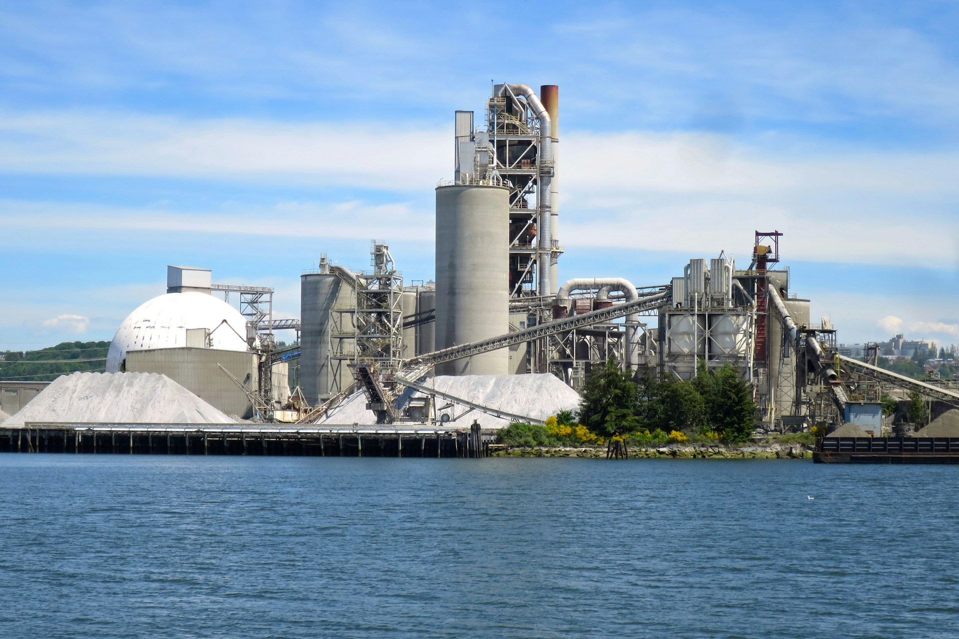a large factory building next to a body of water