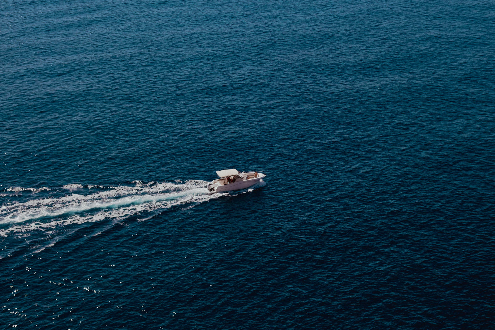 Center console boat running toward the Galveston jetties at sunrise
