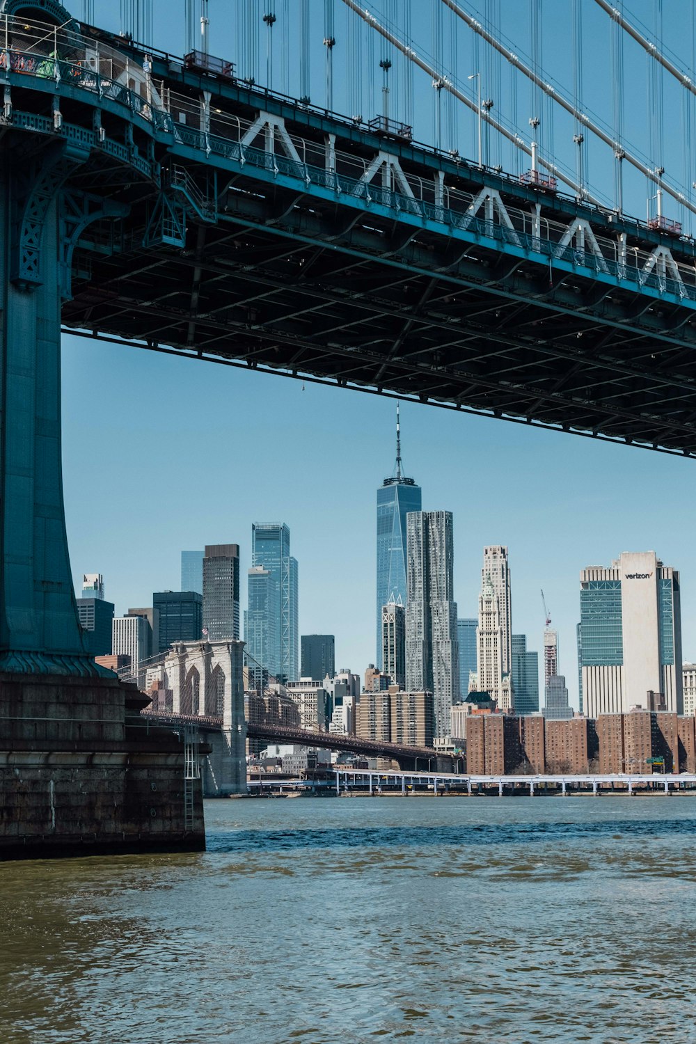 a bridge over a river with a city in the background