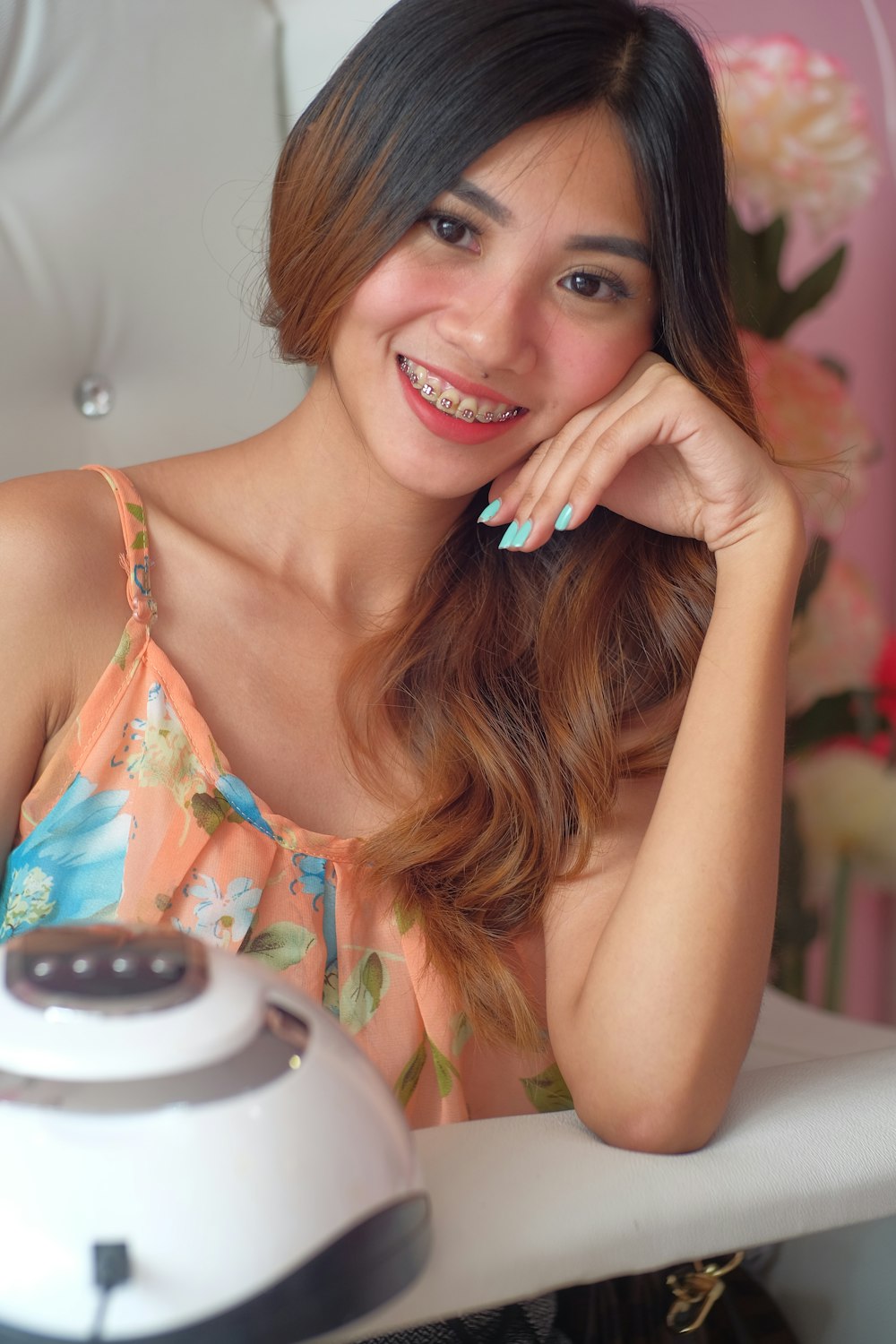 a woman smiling and leaning on a coffee maker