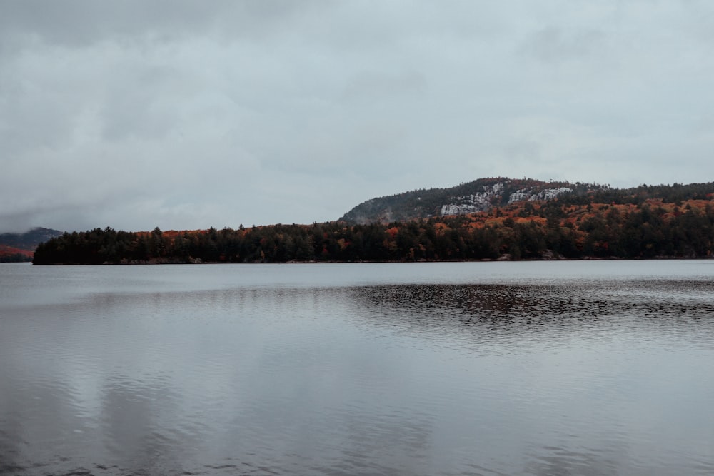 a lake with trees and mountains in the background