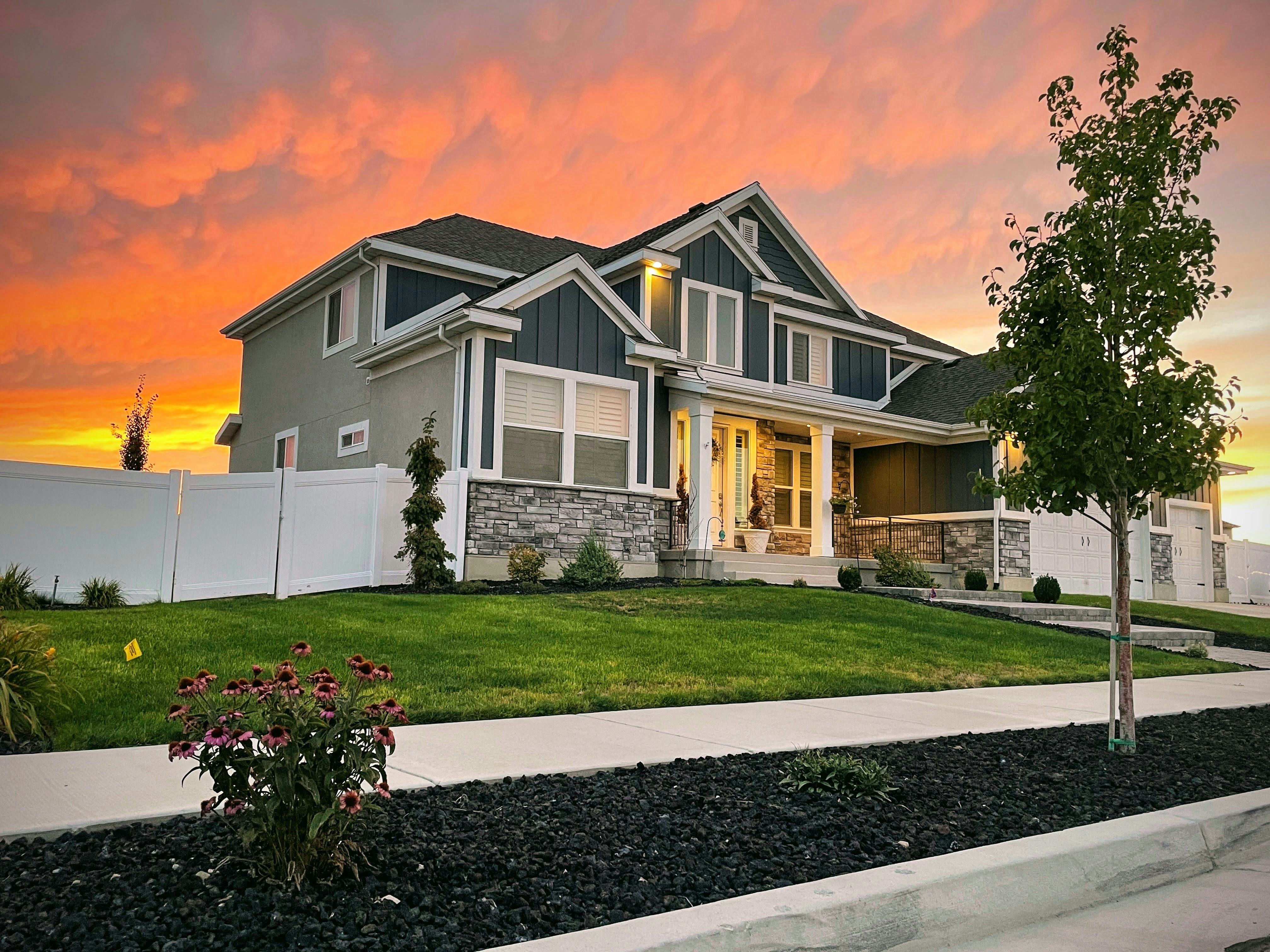 Modern South African home exterior at sunset, warm orange sky — bright warm environment