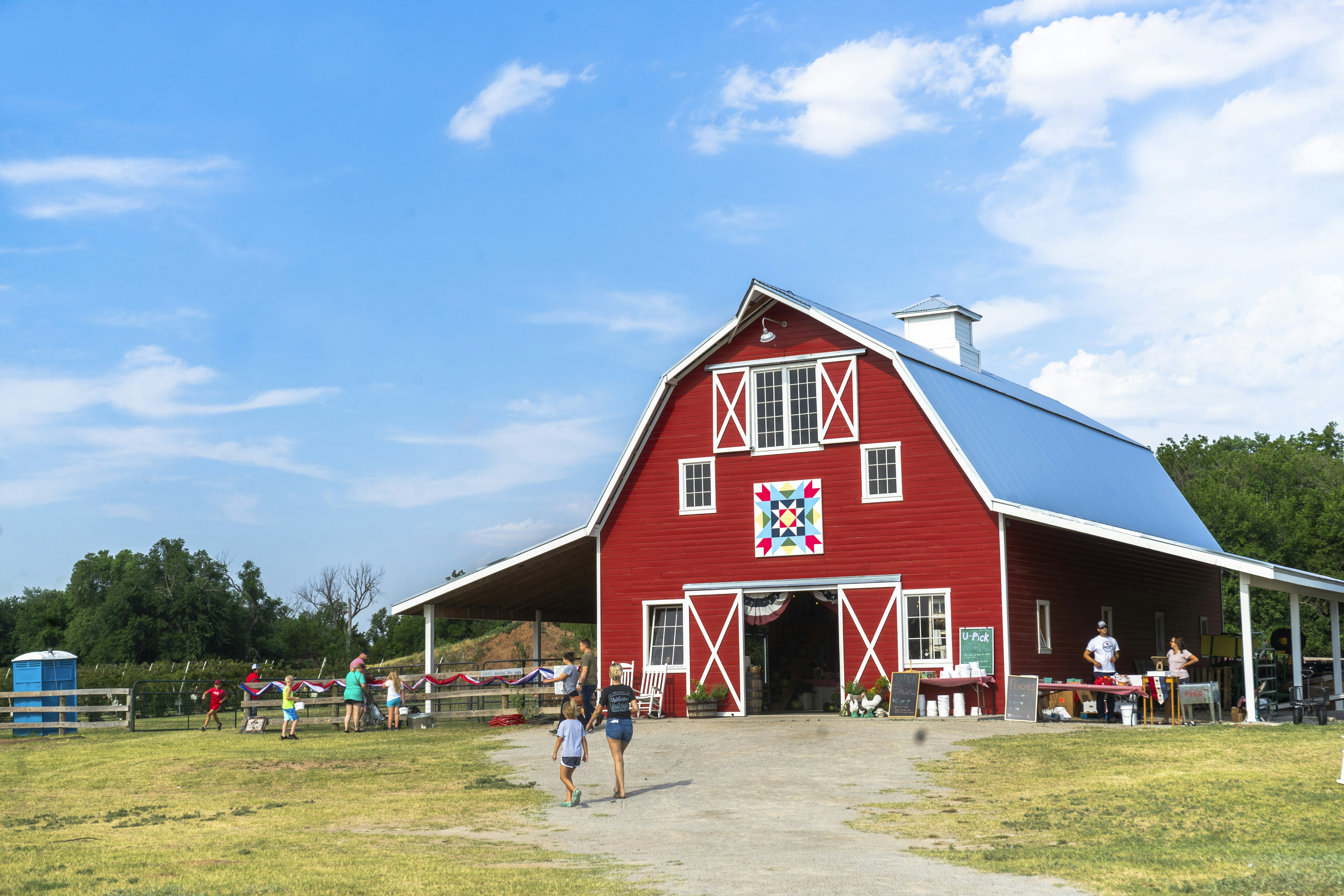 a red barn with people standing in front of it