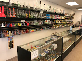 Shelves filled with various smoking accessories and tobacco products in a cozy shop.