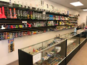 Friendly shop assistant helping a customer with tobacco accessories in a bright store.