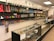 A store interior with shelves and glass display cases filled with a variety of smoking accessories, including glass pipes, bongs, and other paraphernalia. The shelves are well-organized and colorful, showing a range of designs. The space is brightly lit with overhead lights, and the products are arranged in an aesthetically pleasing manner.