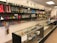 A store interior with shelves and glass display cases filled with a variety of smoking accessories, including glass pipes, bongs, and other paraphernalia. The shelves are well-organized and colorful, showing a range of designs. The space is brightly lit with overhead lights, and the products are arranged in an aesthetically pleasing manner.