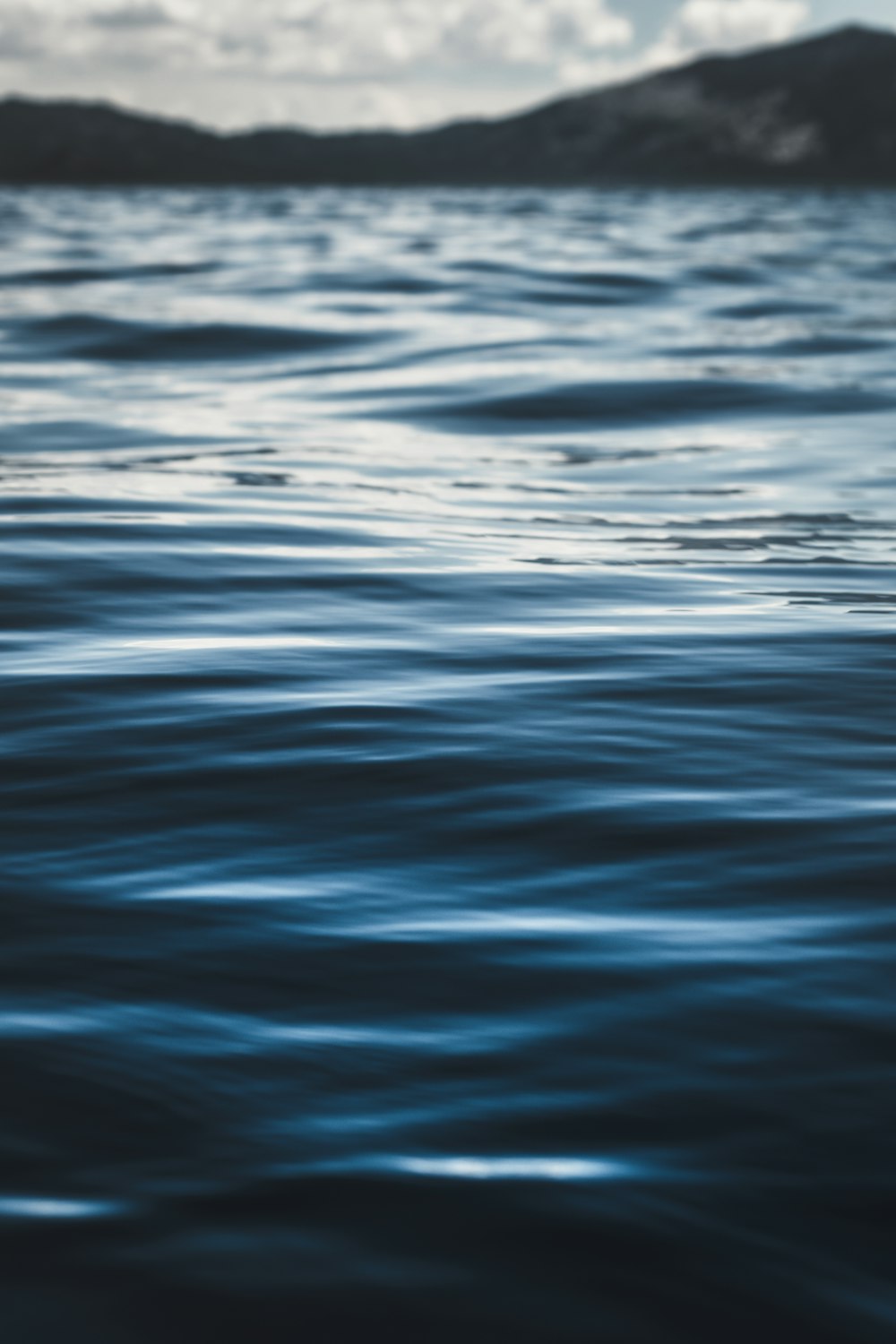 a body of water with mountains in the background