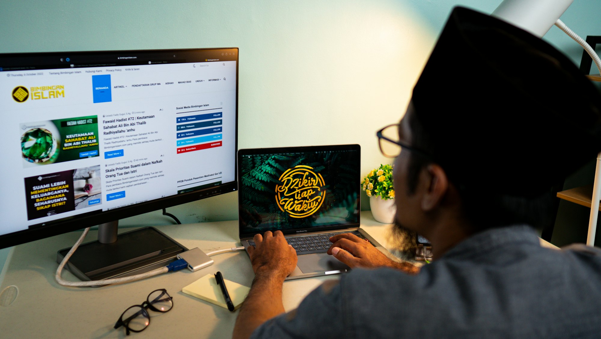 A muslim man working in front of laptop