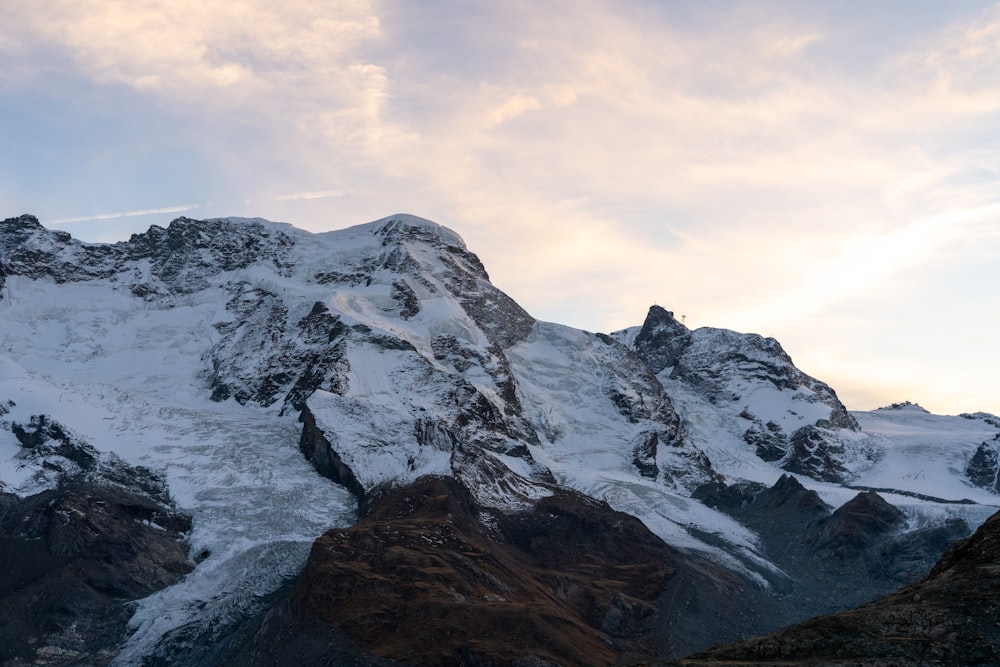 a snowy mountain with clouds