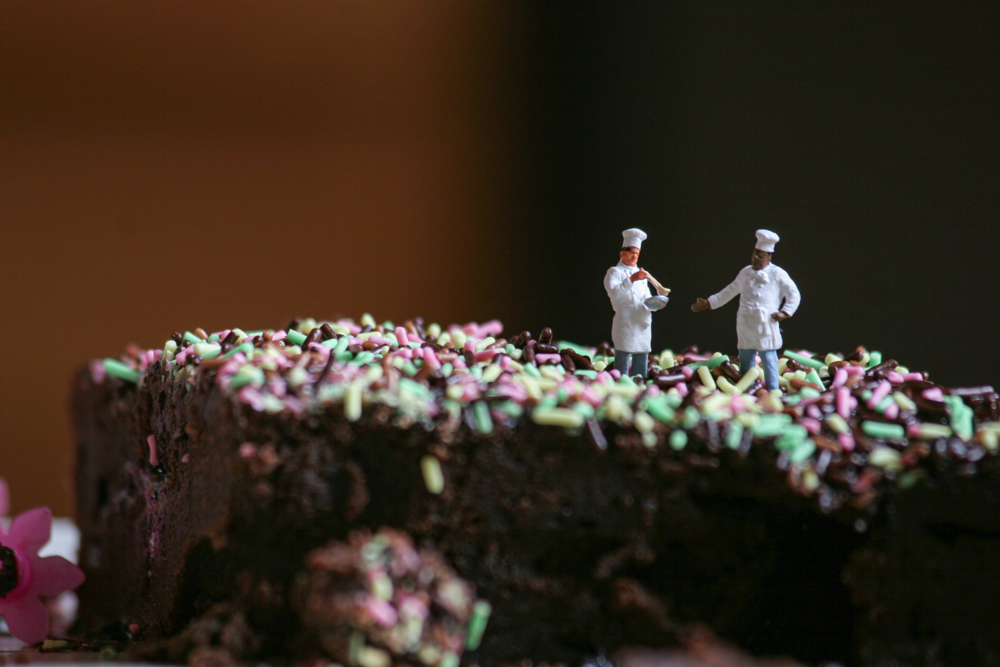 2 miniature cooks on a chocolate cake