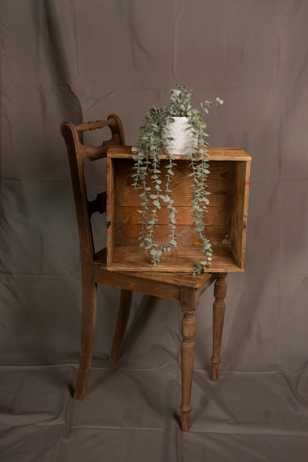 a wooden chair with a vase of flowers on top