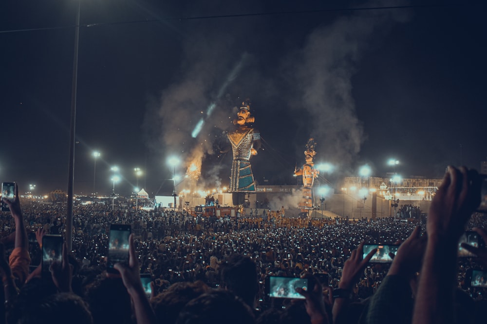 a crowd of people watching a stage with a large crowd watching