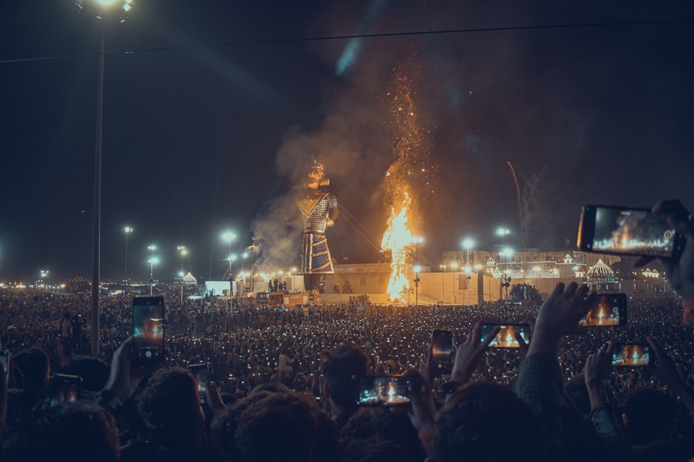 Eine große Menschenmenge, die eine Bühne mit einem großen Feuer beobachtet