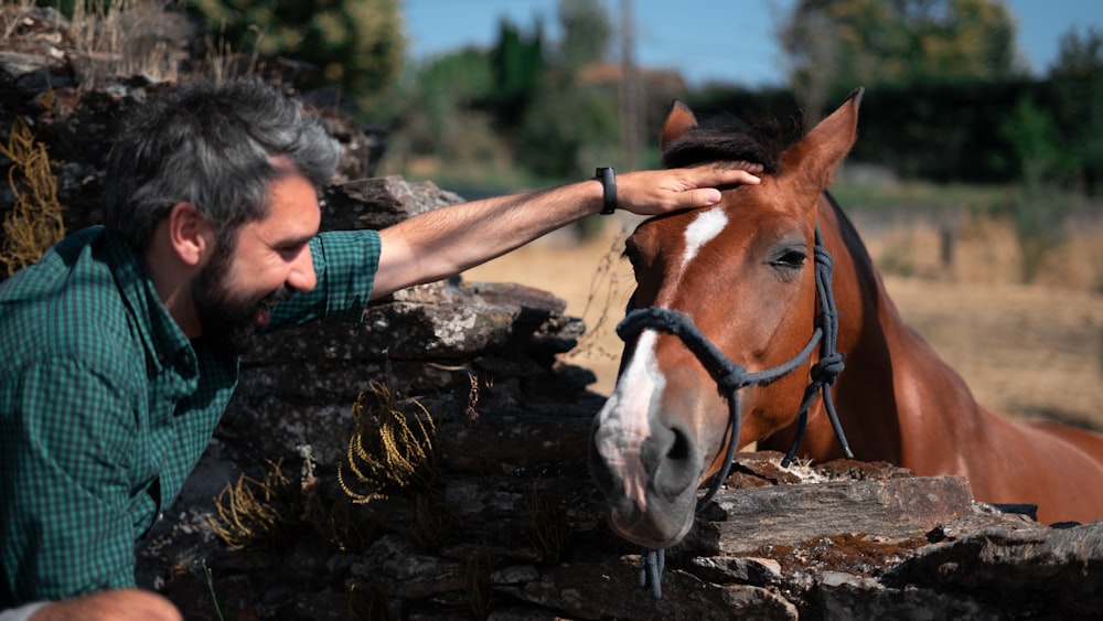 Ein Mann, der ein Pferd berührt