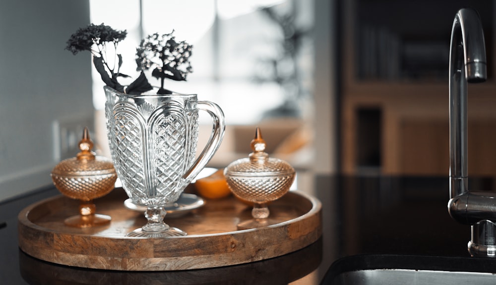 a glass teapot and a pitcher on a table