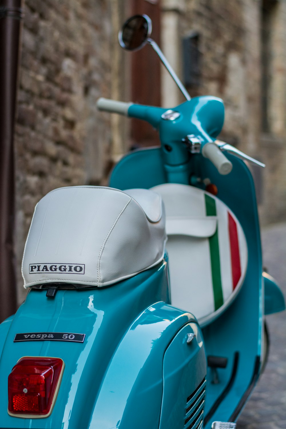 a blue scooter parked on the side of a road