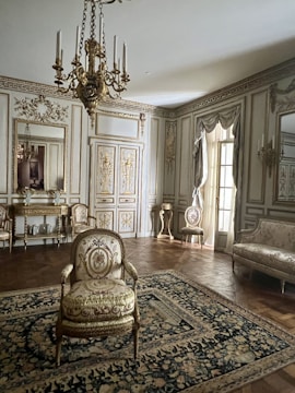 a fancy living room with a chandelier and a chair