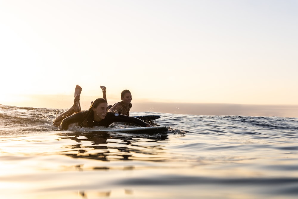 a man and a woman on a surfboard in the water