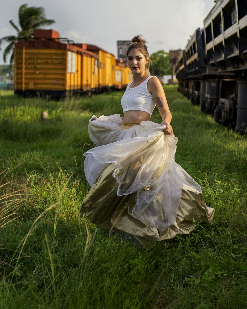 a person in a white dress sitting in a grassy field
