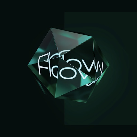 A geometric glass-like structure with multiple facets sits against a dark background. The structure reflects light and creates a glowing effect. The word 'Flow' is visible and may be reflected or refracted through the facets.